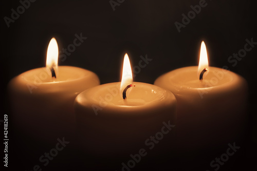 Candles burn in the dark. Close-up.