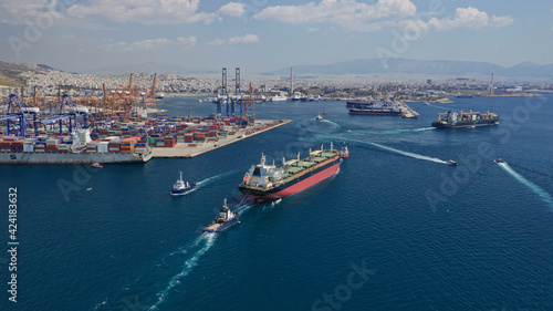 Aerial drone photo of cargo carrier tanker leaving industrial port of Perama with the help of tug boats for Mediterranean destination, Attica, Greece © aerial-drone