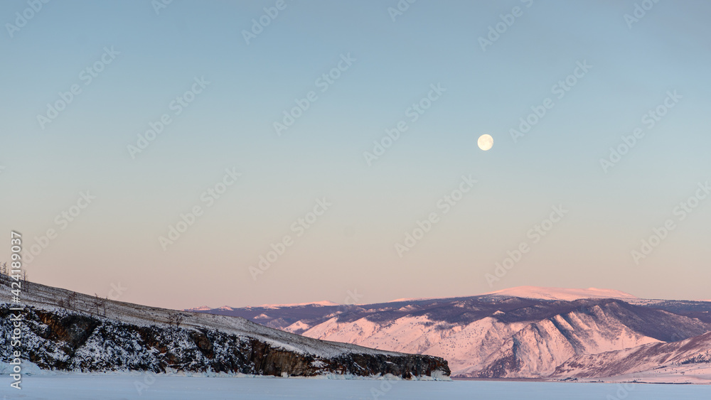 Fototapeta premium Moon in the morning above Baikal lake in winter