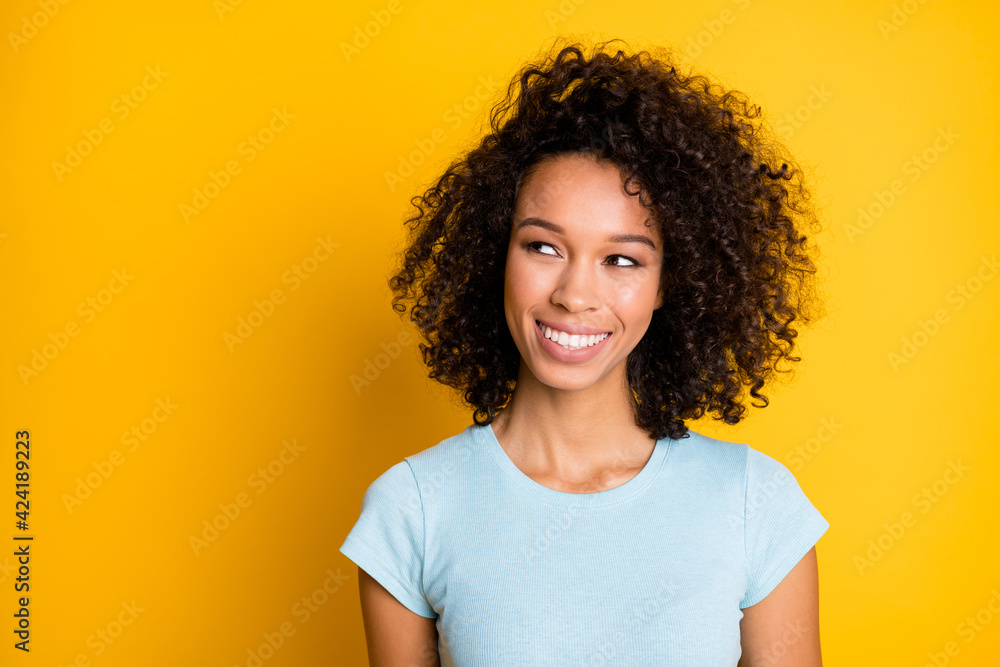 Photo portrait of dreamy afro american woman looking at blank space isolated on vivid yellow colored background Photo portrait of dreamy afro american woman looking at blank space isolated on vivid yellow colored background