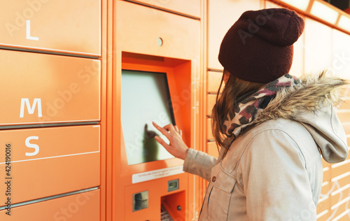 Wallpaper Mural Woman picks up mail from automated self-service post terminal machine