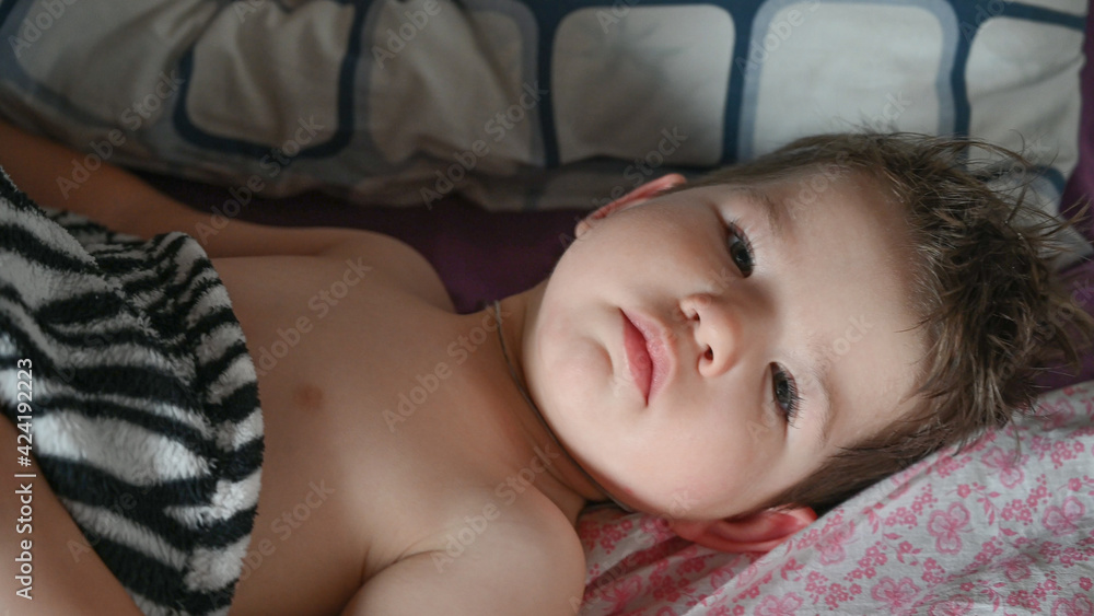 A cute baby who just woke up in the morning. Portrait of caucasian toddler boy in bed A cute baby who just woke up in the morning. Portrait of caucasian toddler boy in bed