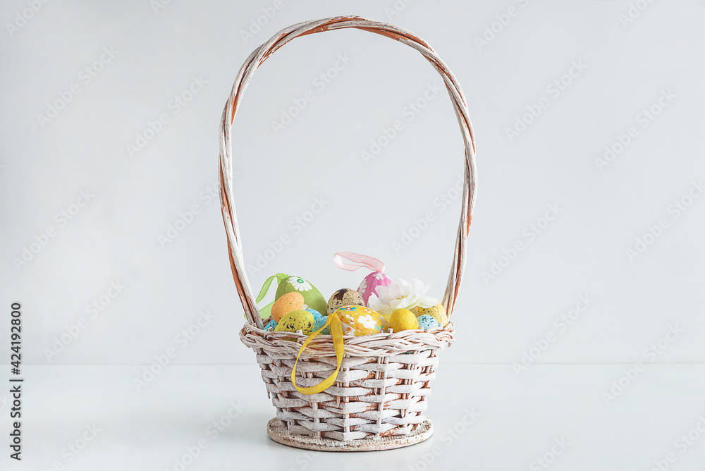 White wicker basket with easter eggs on white background White wicker basket with easter eggs on white background