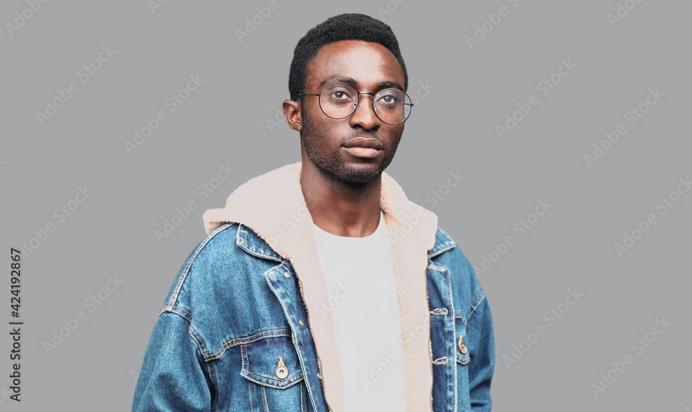 Fototapeta premium Portrait of modern young african man wearing an eyeglasses on a gray background