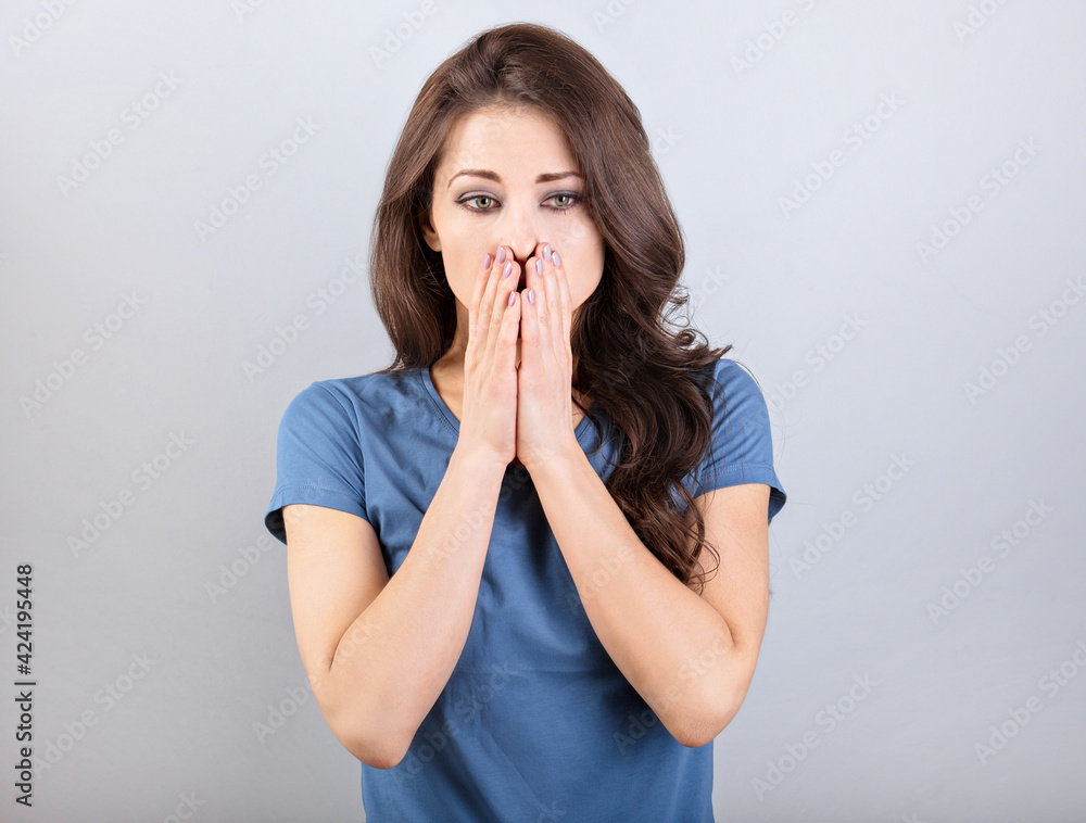 Stressed unhappy business woman closed the face the hands with thinking doubt eyes on blue background. Closeup Stressed unhappy business woman closed the face the hands with thinking doubt eyes on blue background. Closeup