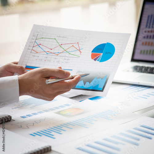 Financial Business man analyze the graph of the company's performance to create profits and growth, Market research reports and income statistics, Financial and Accounting concept.