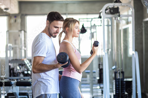Sporty couple make weight lifting together in loft gym