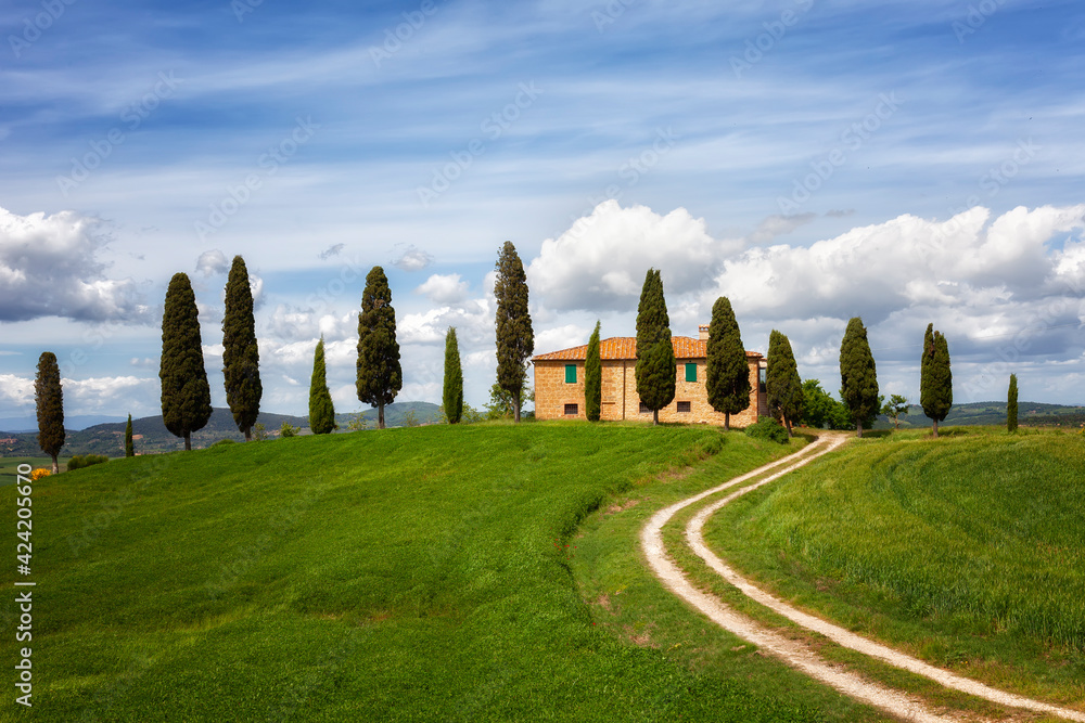 Beautiful rural landscape with the stone house, cypresses and a twisting path, Tuscany, Italy