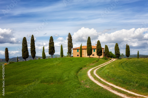 Beautiful rural landscape with the stone house  cypresses and a twisting path  Tuscany  Italy