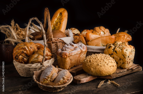 Still life of a variety of bread on a black background, bakery banner