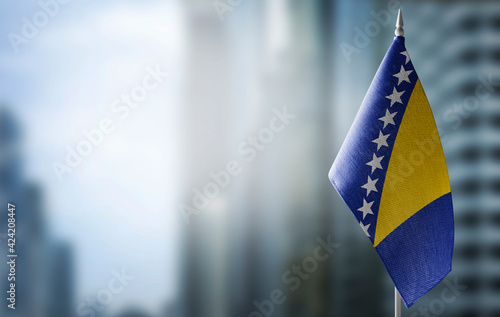 Foto A small flag of Bosnia and Herzegovina on the background of a blurred background