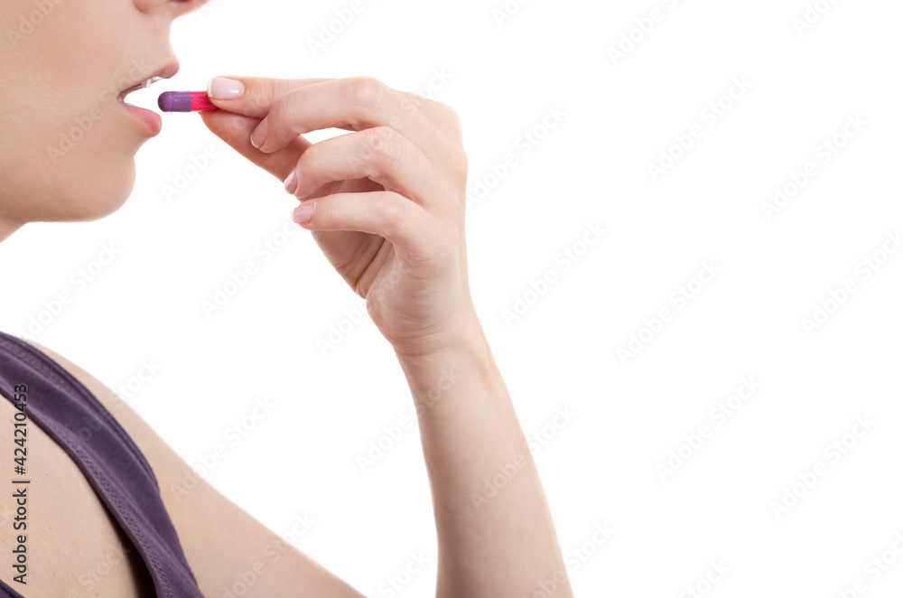 young woman taking pill over white background young woman taking pill over white background