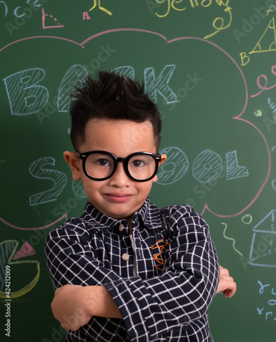 Asian Little boy in casual smile on blackboard.