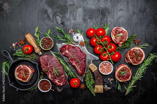 Variety of raw black angus prime meat steaks beef rump steak, Tenderloin fillet mignon for grilling on old meat cleaver on dark background. banner, menu recipe top view photo