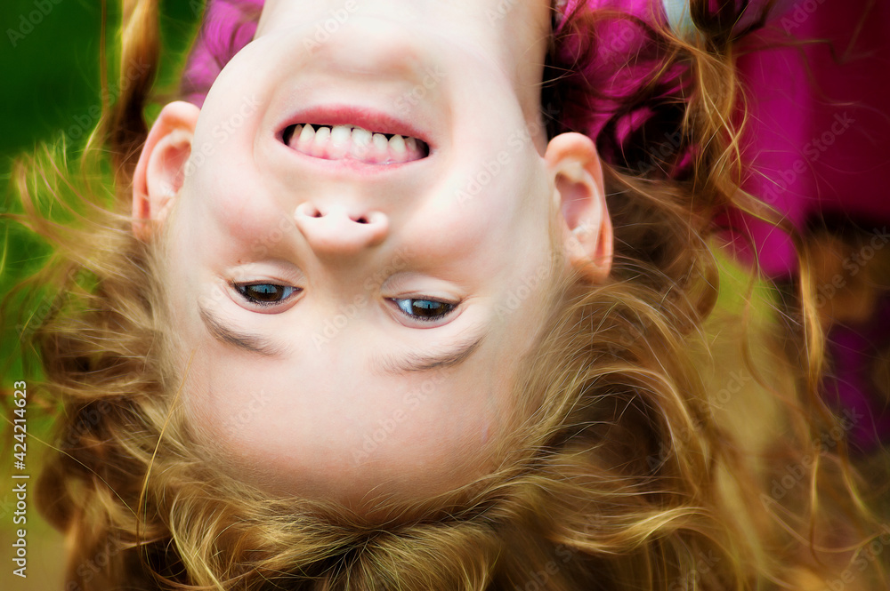 Little Girl her head hanging upside down foto de Stock | Adobe Stock
