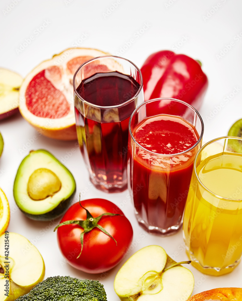 freshly squeezed fruit juice in glass glasses with a composition of fruit on a light background freshly squeezed fruit juice in glass glasses with a composition of fruit on a light background