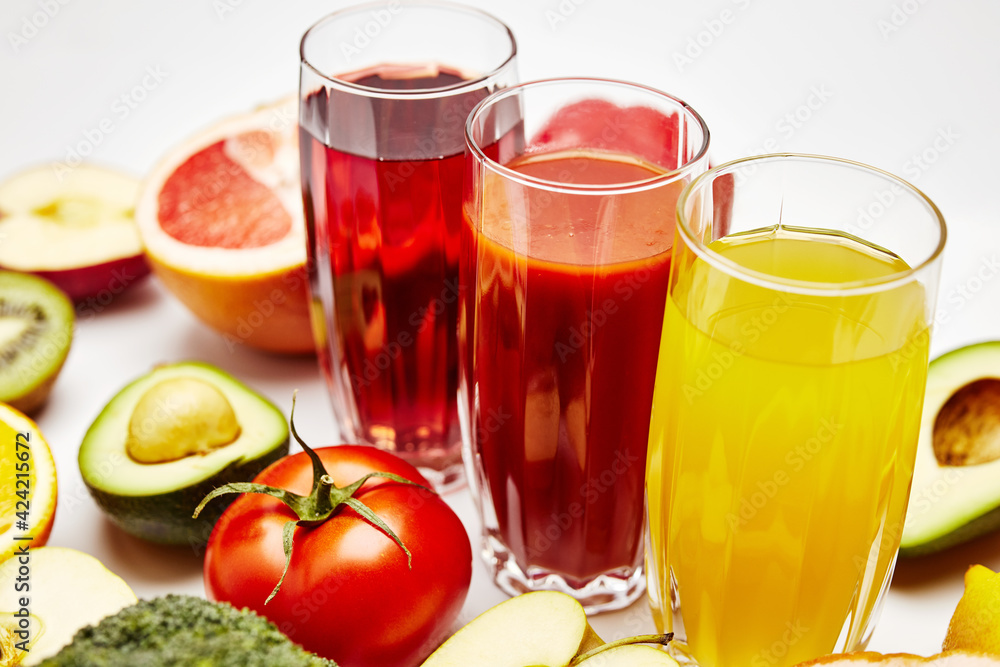 freshly squeezed fruit juice in glass glasses with a composition of fruit on a light background freshly squeezed fruit juice in glass glasses with a composition of fruit on a light background
