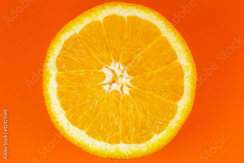 Orange fruit on orange background. Minimalism, original beautiful photo.