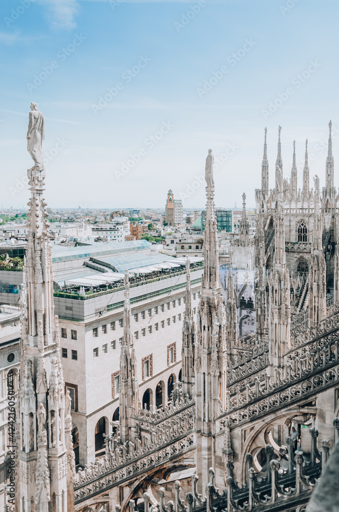Roof of Milan Cathedral Duomo di Milano with Gothic spires and white marble statues. Top tourist attraction on piazza in Milan, Italy. Roof of Milan Cathedral Duomo di Milano with Gothic spires and white marble statues. Top tourist attraction on piazza in Milan, Italy.