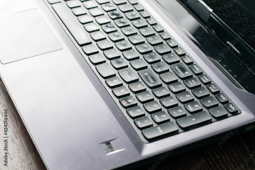 Laptop, keyboard close-up on a dark wooden table, copy space. Remote study or work concept. Laptop, keyboard close-up on a dark wooden table, copy space. Remote study or work concept.