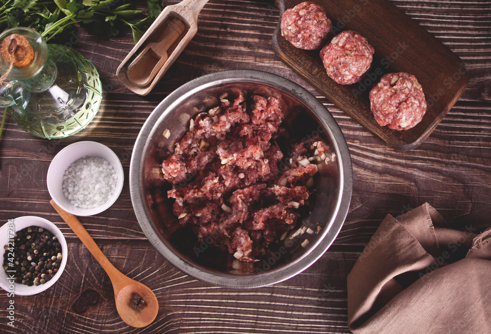 fresh raw minced beef in a plate on a rustic wooden table with ingredients fresh raw minced beef in a plate on a rustic wooden table with ingredients