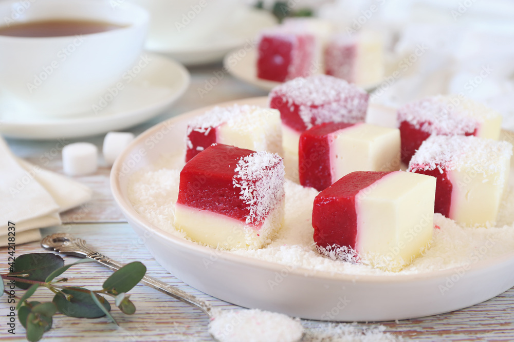 Homemade panna cotta and red fruits cubes in coconut flakes and two cups of tea Homemade panna cotta and red fruits cubes in coconut flakes and two cups of tea