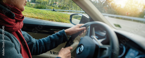 Woman driver entering difficult corner on the rural highway with 35 km mph per hour speed on the digital display dashboard speedometer photo