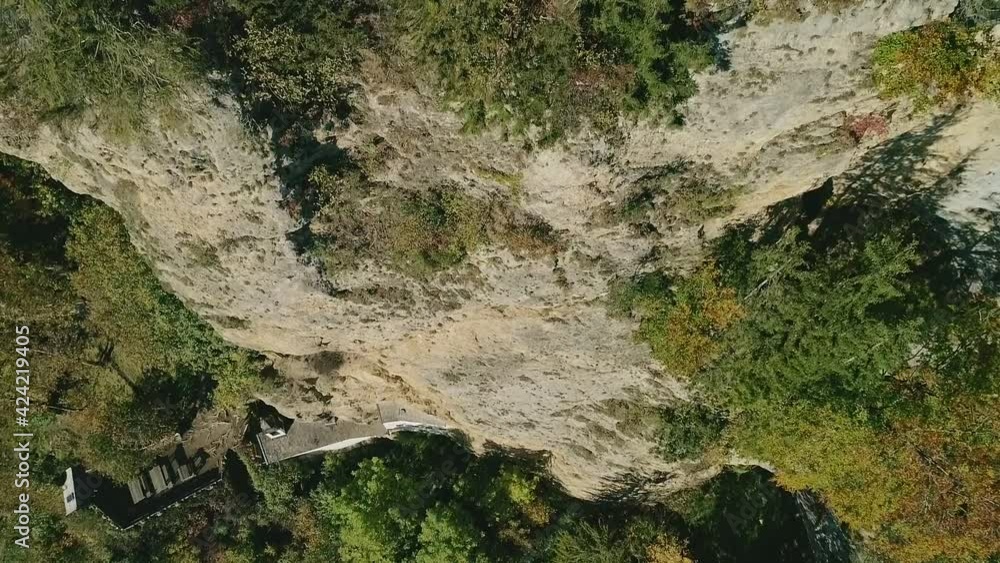 An aerial drone shot flying over the edge of a rocky cliff looking straight down. Daytime. An aerial drone shot flying over the edge of a rocky cliff looking straight down. Daytime.