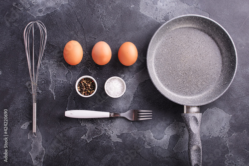 the ingredients for making scrambled eggs are laid out on a dark stone background