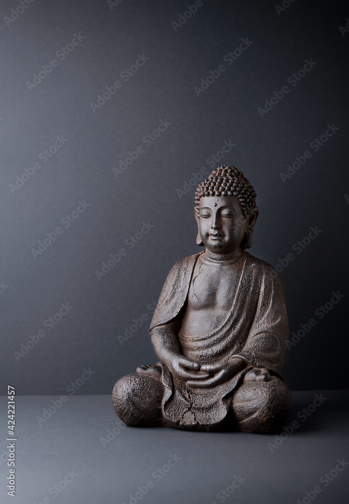 Meditating Buddha Statue on paper background. Copy space.	