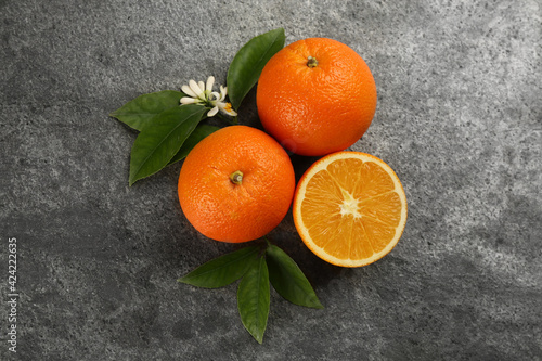 Delicious ripe oranges on grey table, flat lay