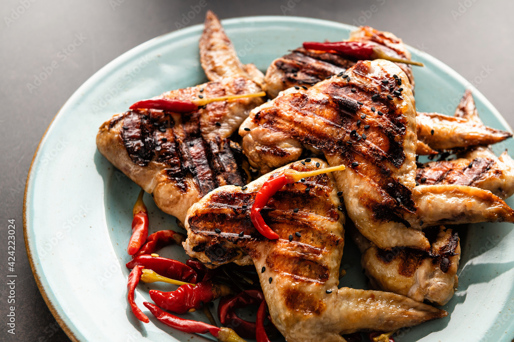 grilled chicken wings laid out on a plate in a bunch, sprinkled with chili grilled chicken wings laid out on a plate in a bunch, sprinkled with chili