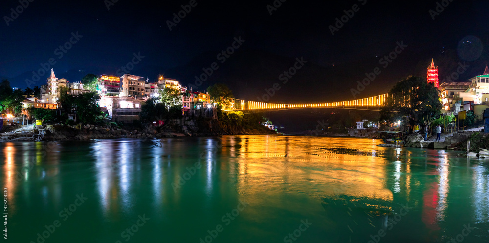 Spectacular illuminated panoramic cityscape of Rishikesh, the yoga capital of World located in foothills Himalayas along banks of river Ganga or Ganges in Uttarakhand state of India.