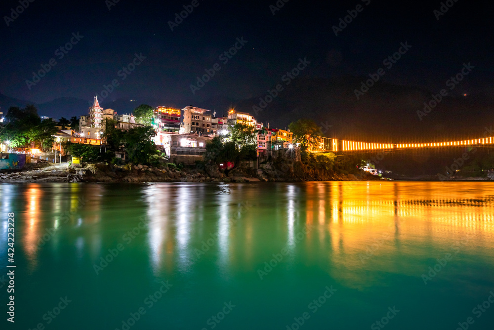 Spectacular illuminated panoramic cityscape of Rishikesh, the yoga capital of World located in foothills Himalayas along banks of river Ganga or Ganges in Uttarakhand state of India.