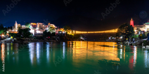 Spectacular illuminated panoramic cityscape of Rishikesh, the yoga capital of World located in foothills Himalayas along banks of river Ganga or Ganges in Uttarakhand state of India. photo