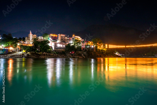 Spectacular illuminated panoramic cityscape of Rishikesh, the yoga capital of World located in foothills Himalayas along banks of river Ganga or Ganges in Uttarakhand state of India.