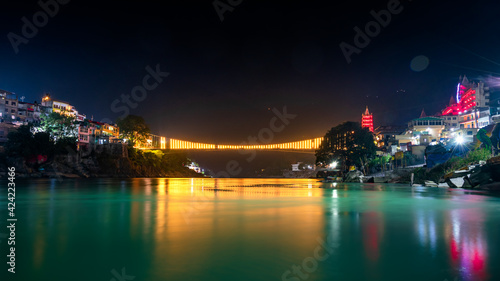 Spectacular illuminated panoramic cityscape of Rishikesh, the yoga capital of World located in foothills Himalayas along banks of river Ganga or Ganges in Uttarakhand state of India. © anjali04