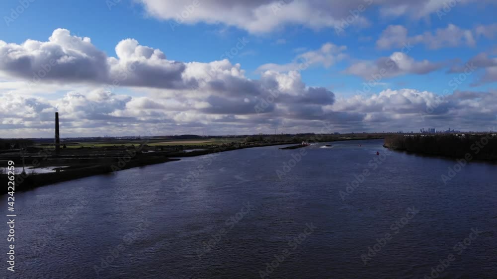 Cloudscape Over Serene River Of Oude Maas Near Riverbanks Of Puttershoek Town In Western Netherlands. - Aerial Wide Shot Cloudscape Over Serene River Of Oude Maas Near Riverbanks Of Puttershoek Town In Western Netherlands. - Aerial Wide Shot