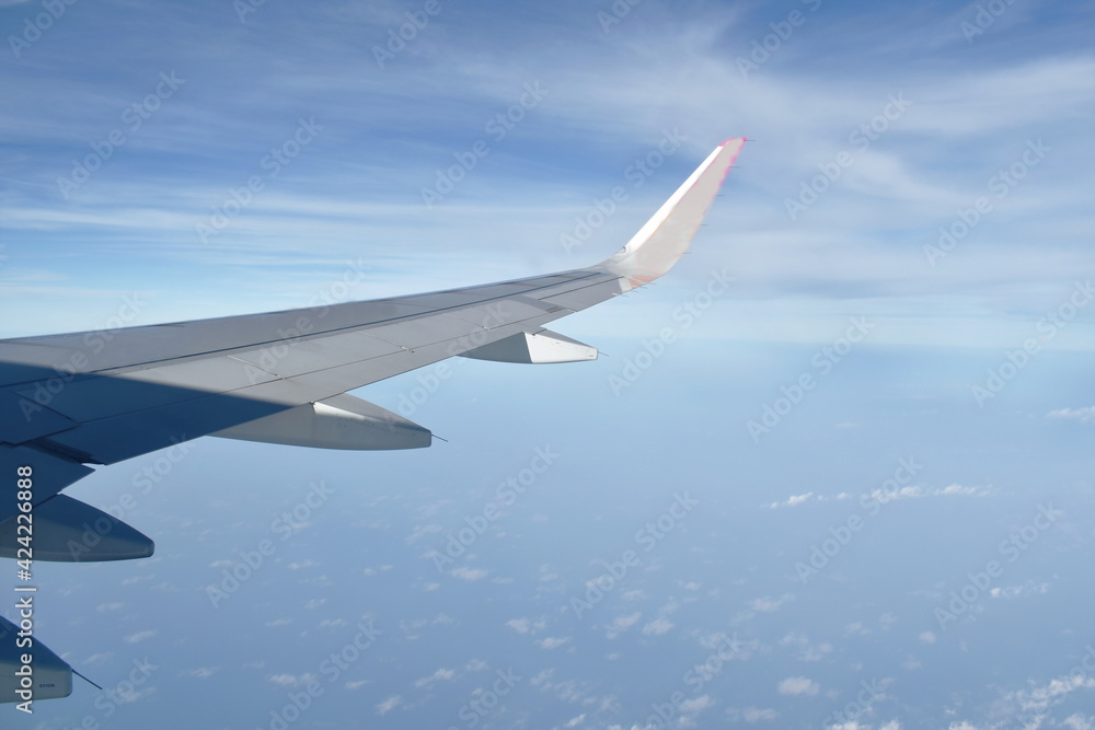 Obraz premium plane wing and cloud floating on sky through window frame