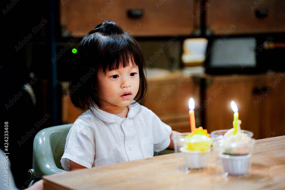 Asian baby prepare blowing her secound birthday candle on cupcake at home. Asian baby prepare blowing her secound birthday candle on cupcake at home.