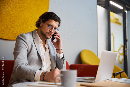 Concentrated bearded male person talking per telephone