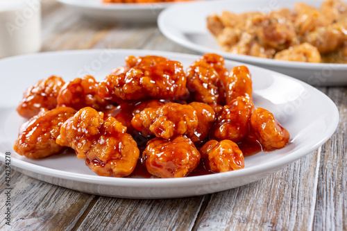 A view of a plate of sweet glazed boneless chicken wings.