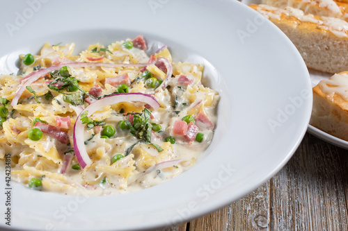 A view of a plate of farfalle pasta with Alfredo sauce.
