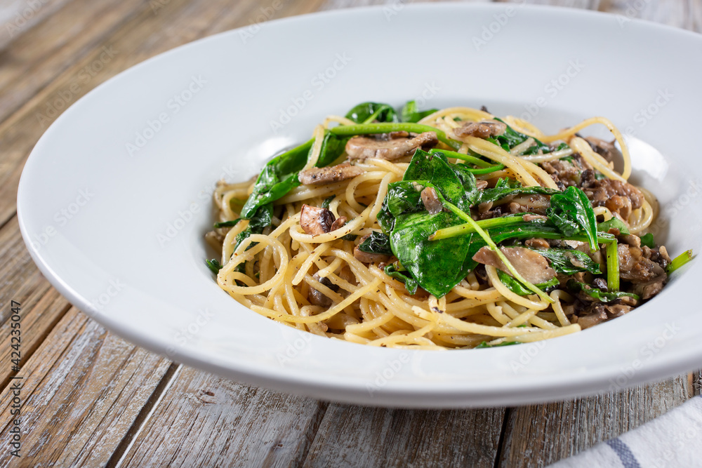 A view of a plate of spaghetti and mushrooms.