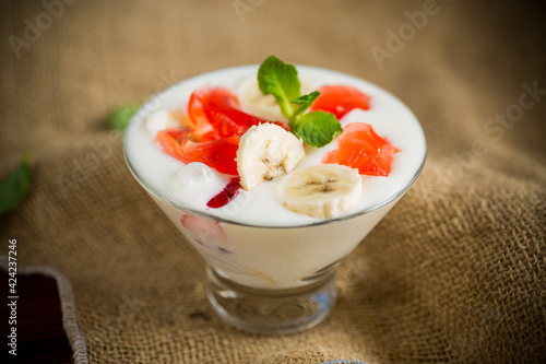 homemade sweet yogurt with bananas and pieces of fruit jelly