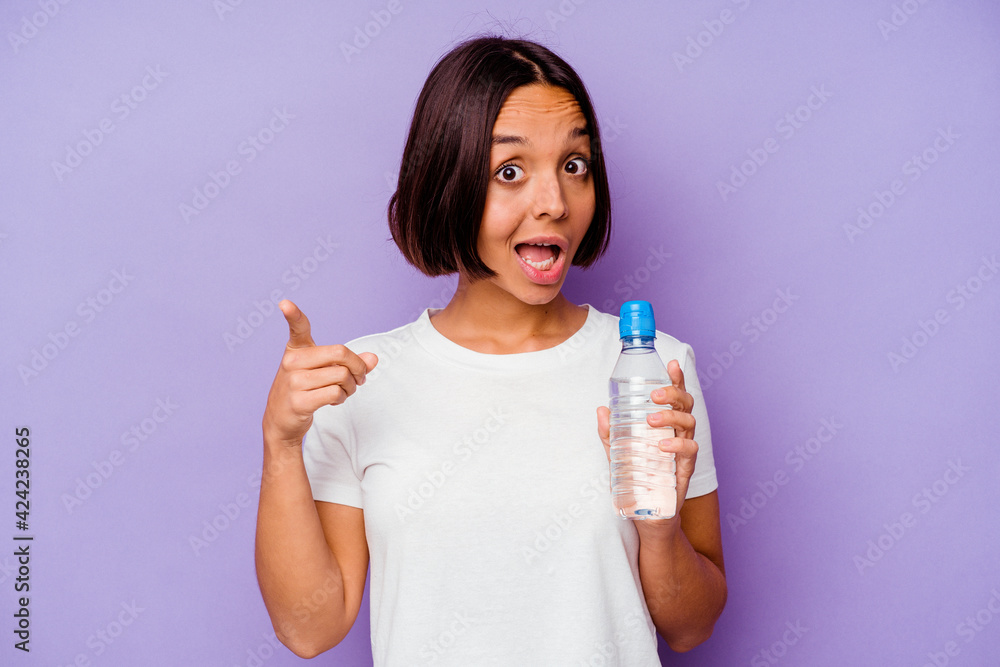 Young mixed race holding a water bottle isolated on purple background having an idea, inspiration concept. Young mixed race holding a water bottle isolated on purple background having an idea, inspiration concept.