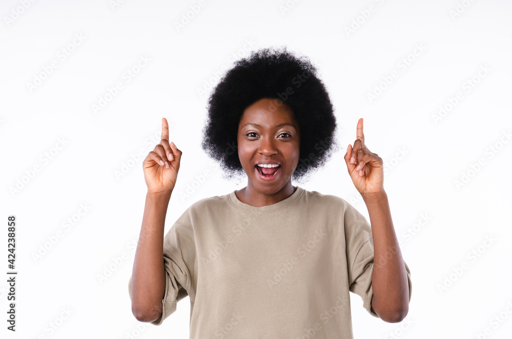 Excited african teenage girl pointing at copy space isolated in white background Excited african teenage girl pointing at copy space isolated in white background