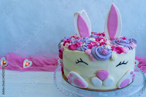 Trendy cake for Easter or Birthday. Blank greeting card. Cheerful bunny with a muzzle and ears. Easter cake. Children s holiday. Copy space.
