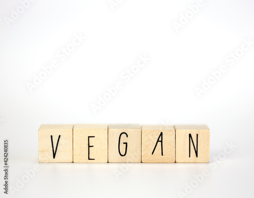 Vegan and hashtag written with wooden cubes and nature decoration isolated on white background with copy space, vegan,vegetarian,health concept background modern design natural style