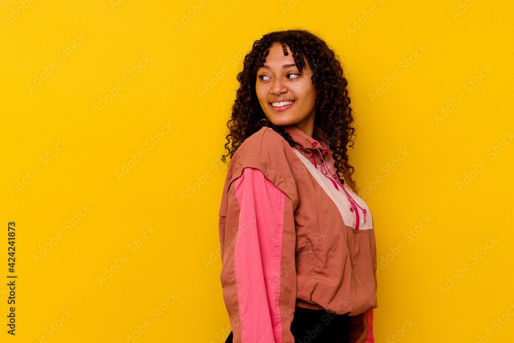 Young mixed race woman isolated on pink background looks aside smiling, cheerful and pleasant. Young mixed race woman isolated on pink background looks aside smiling, cheerful and pleasant.